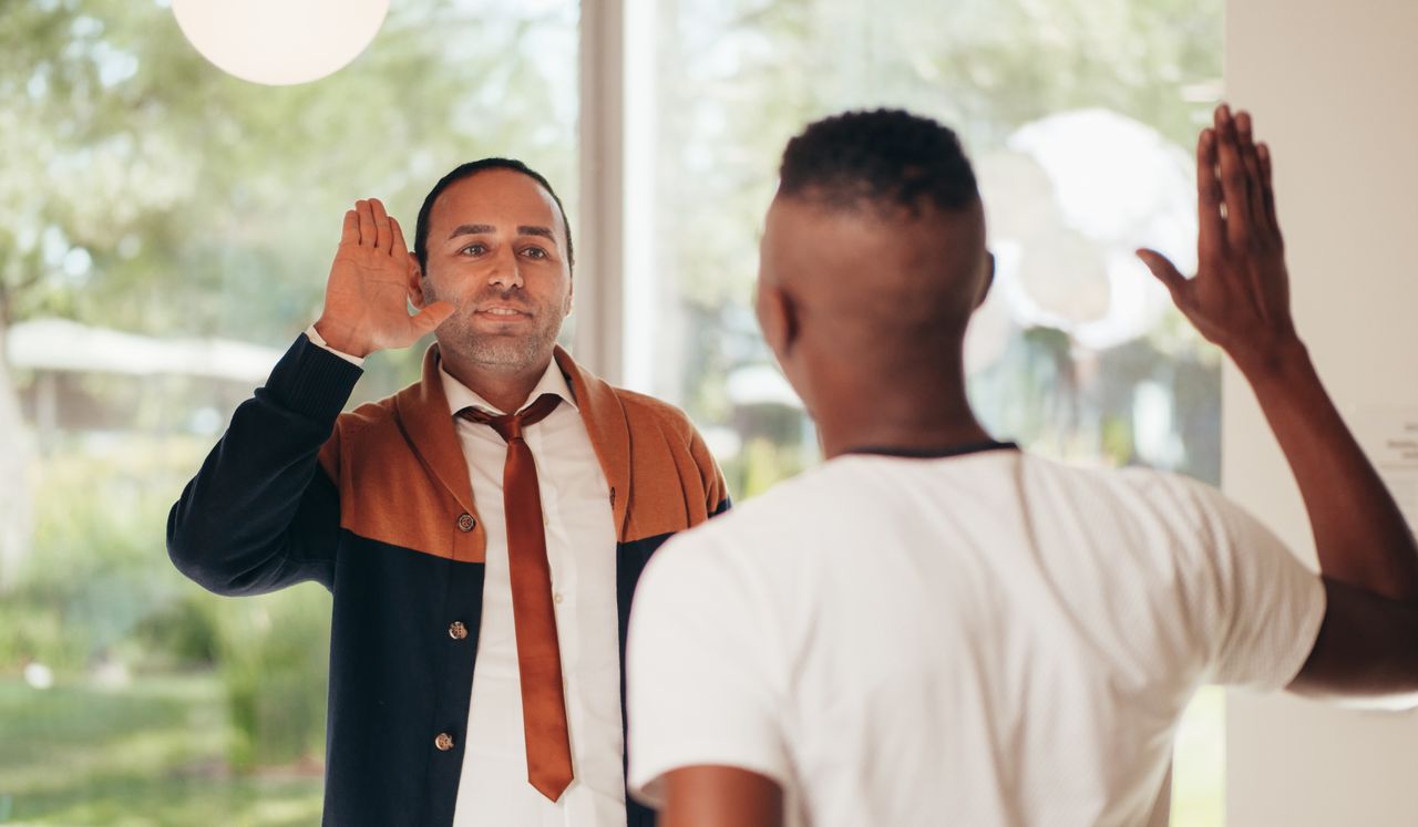 Two diverse business colleagues exchanging a high five in an office setting.